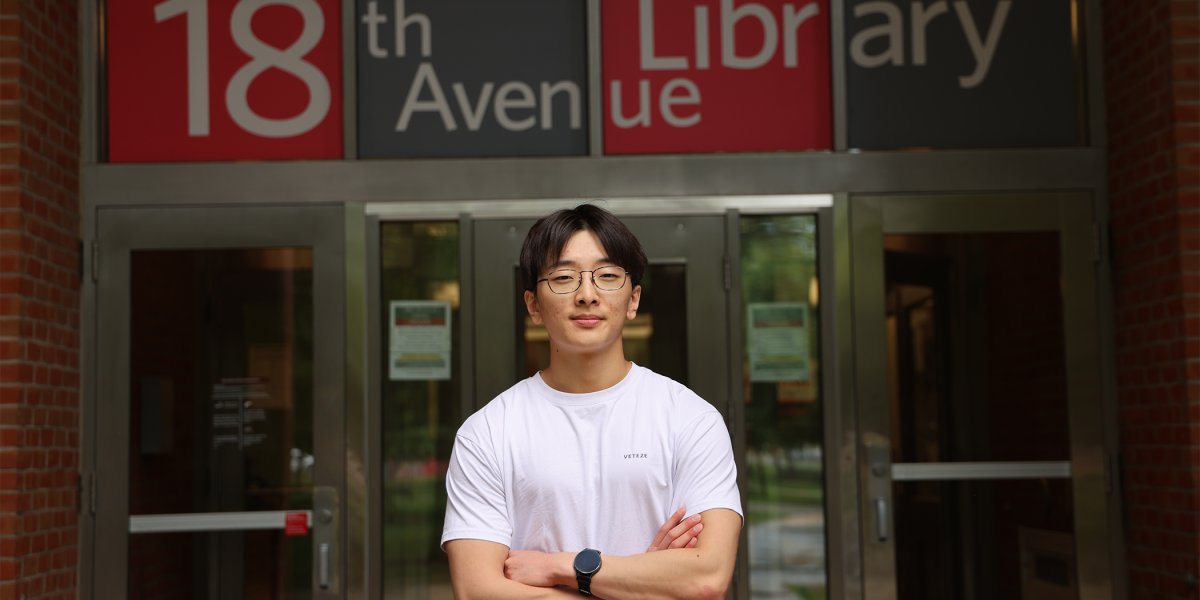 Justin Lee stands with arms crossed in front of 18th Avenue Library