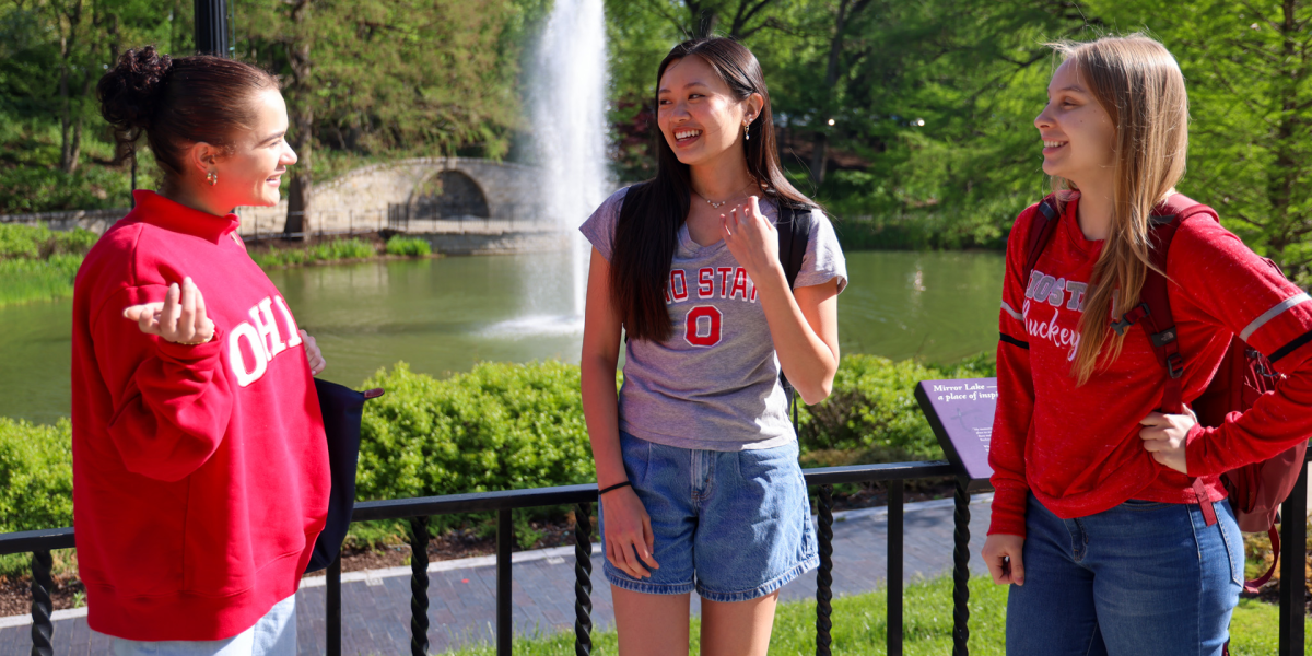Three people are standing outdoors near Mirror Lake