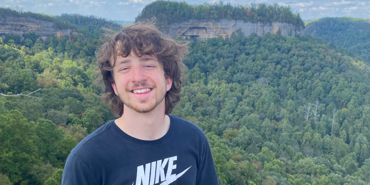 Wyatt Walker stands on a hill in a black Nike shirt smiling