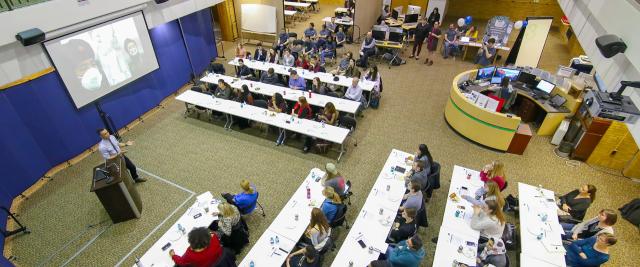 Audience watching a presenter at a 3 Minute Thesis event