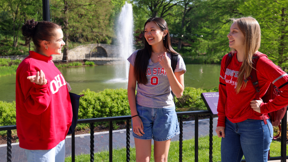 Three people are standing outdoors near Mirror Lake