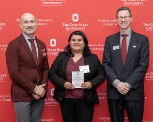 Dr. Lorena Rosas accepts mentor award with two others in front of red ohio state logo'd wall